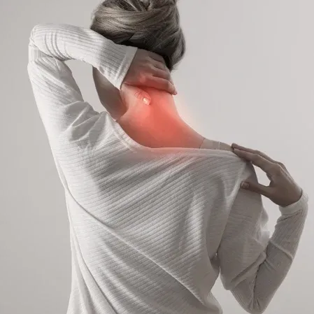 Person holding the back of their neck with the painful area highlighted.